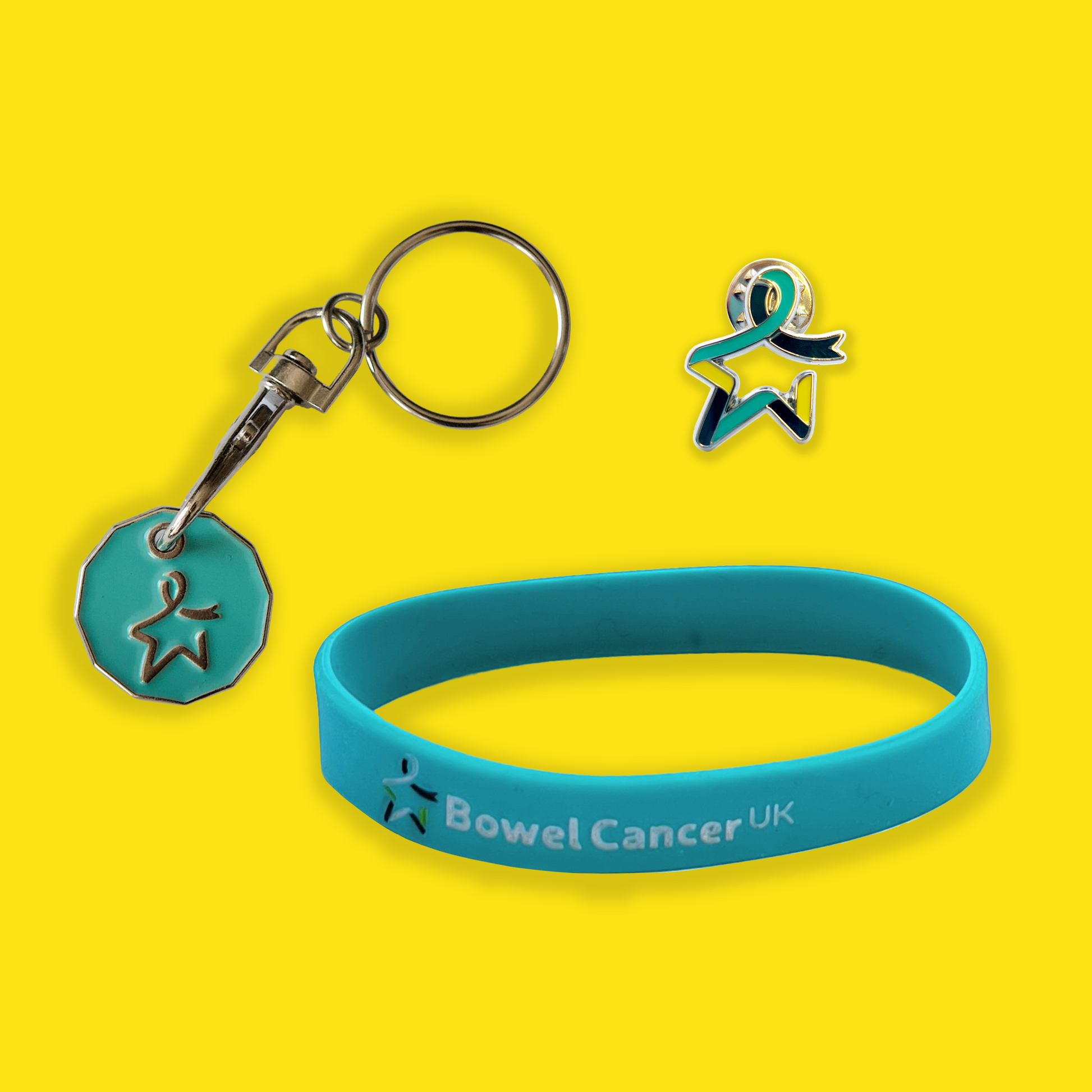 Three Awareness Essentials bundle products are displayed against a yellow background: a teal trolley coin with a Star of Hope engraved on the front; a multi-coloured pin badge  in the shape of the Star of Hope; and a teal wristband printed with a multicoloured Star of Hope and the words “Bowel Cancer UK” in white.