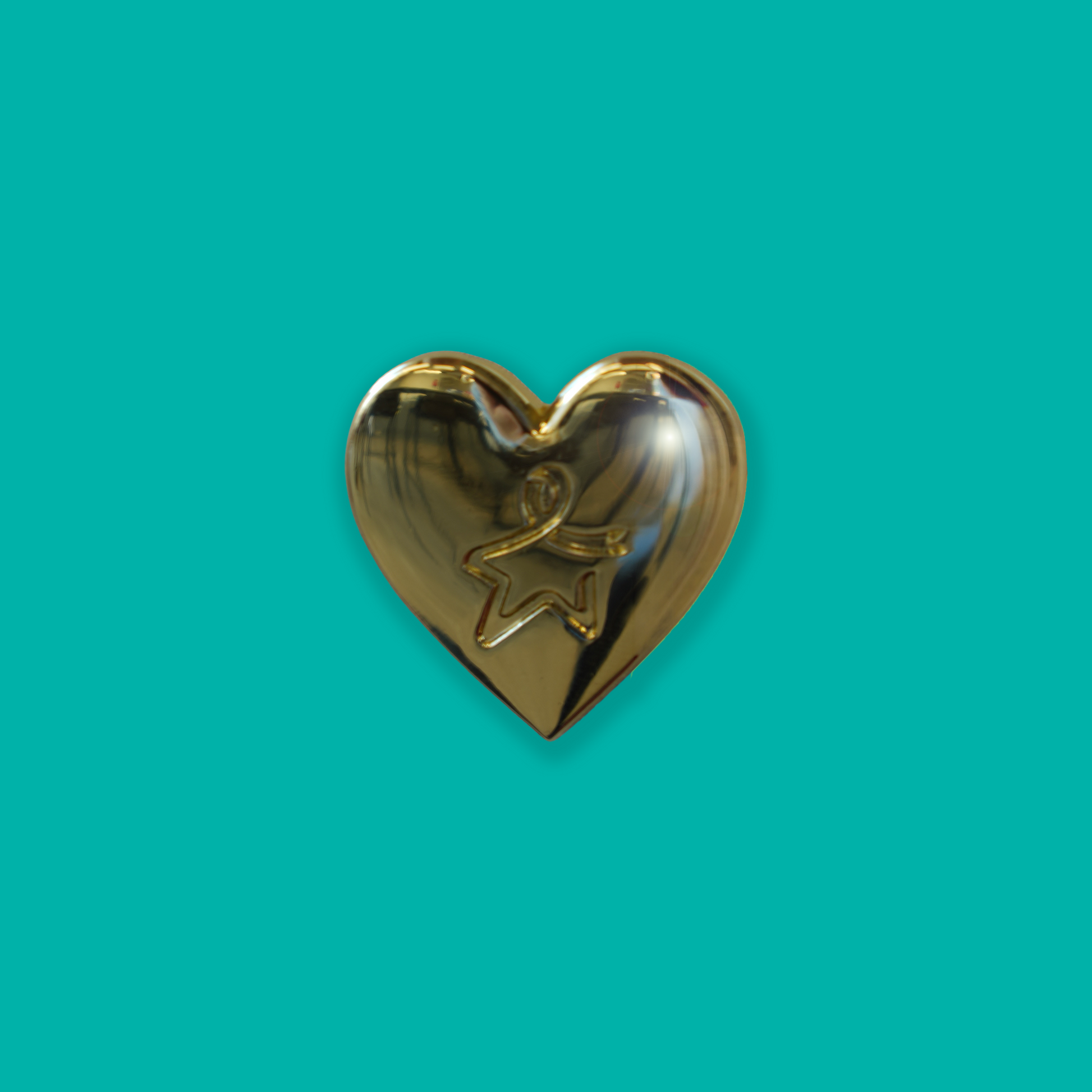 Gold heart‑shaped pin badge with an engraved Star of Hope, shown against a light teal background.