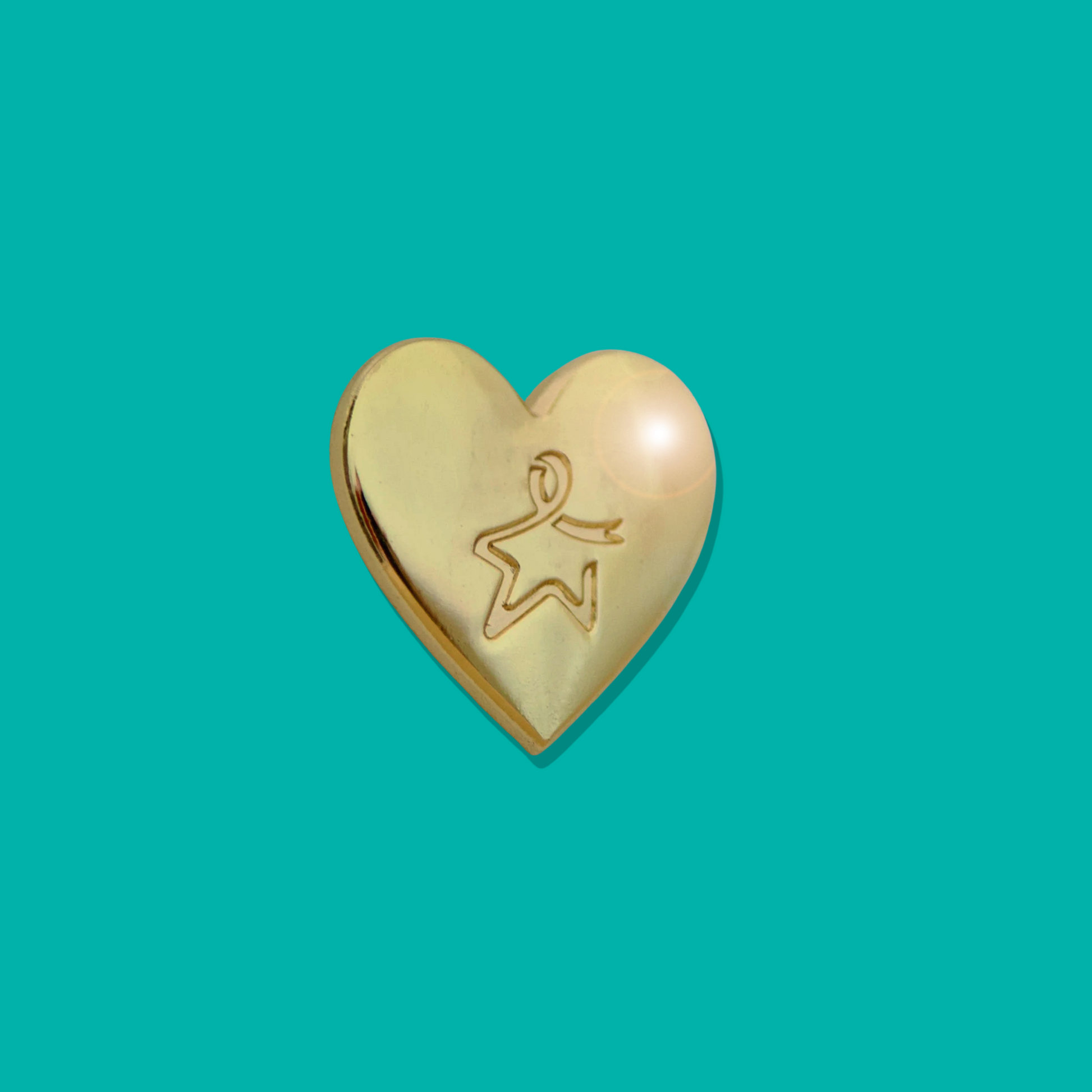 Gold heart‑shaped pin badge with an engraved Star of Hope, shown against a light teal background.