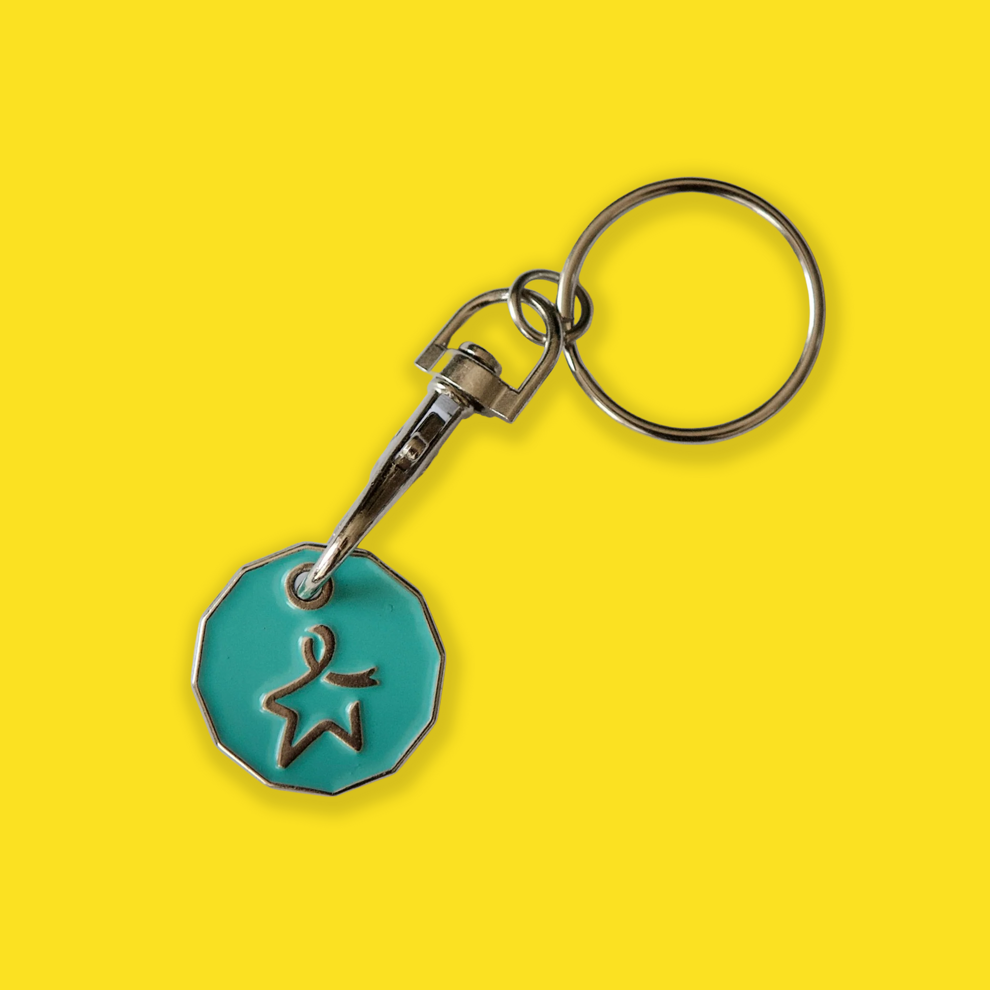 Keychain with a teal trolley coin featuring an engraved Star of Hope, shown against a yellow background.